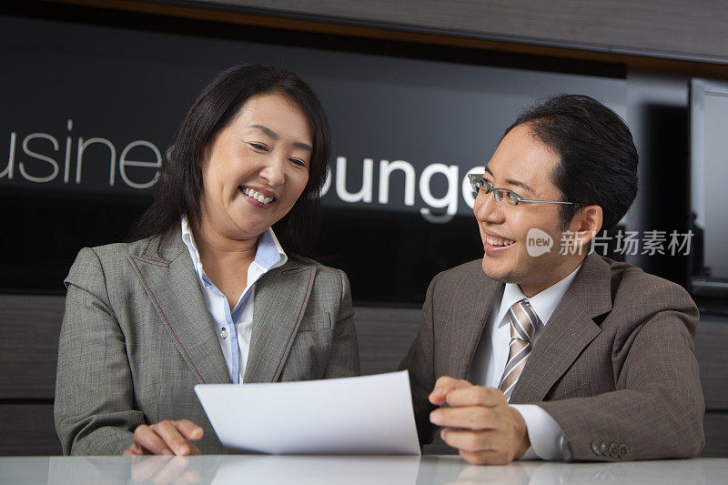 快乐的日本商人和女商人在商务休息室工作