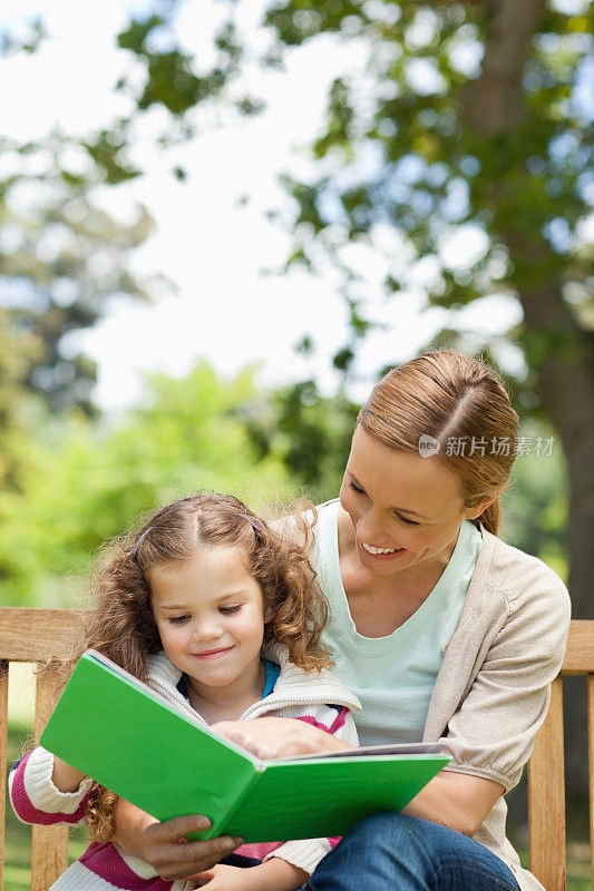 女孩笑着和她妈妈一起读书