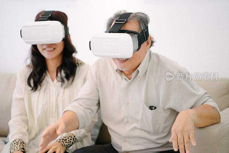 戴着虚拟现实头盔的老年夫妇