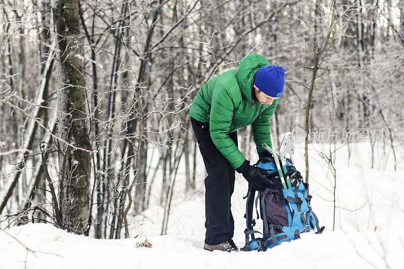 男性的徒步旅行者穿着雪鞋走