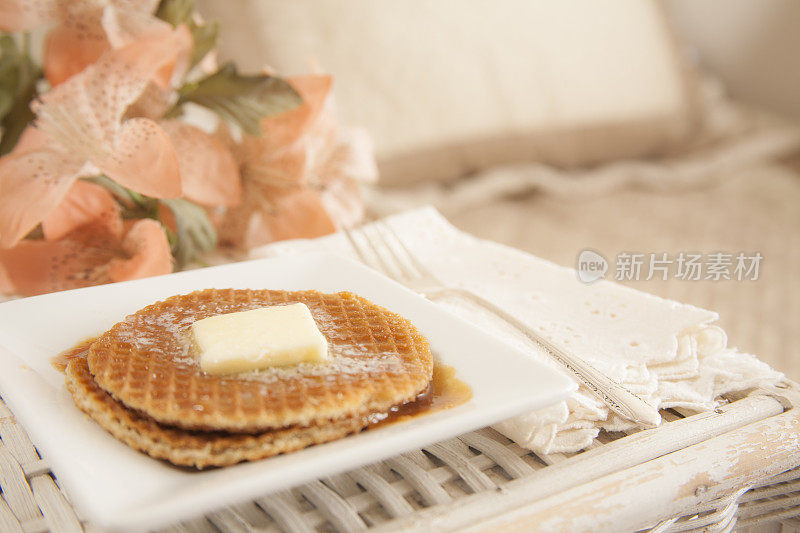 早餐黄油华夫饼放在床上的托盘上。