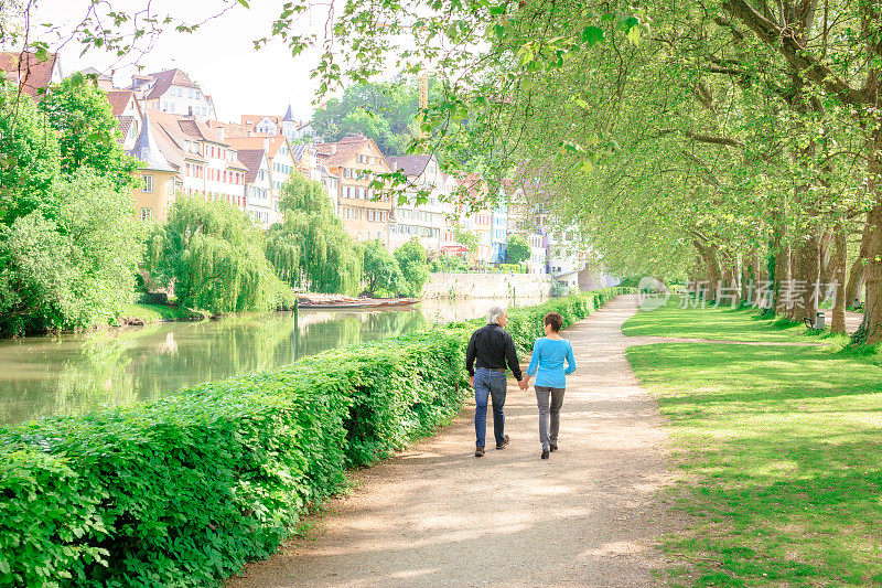 一对老年夫妇穿过公园，Tübingen，德国