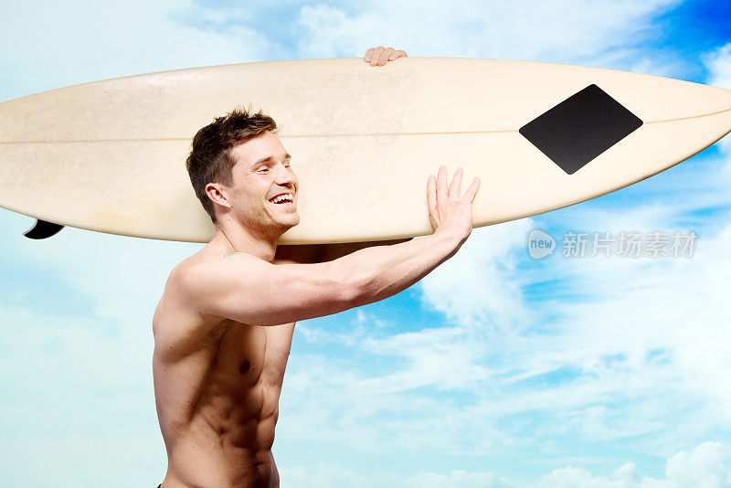 赤裸上身的肌肉冲浪者持有冲浪板