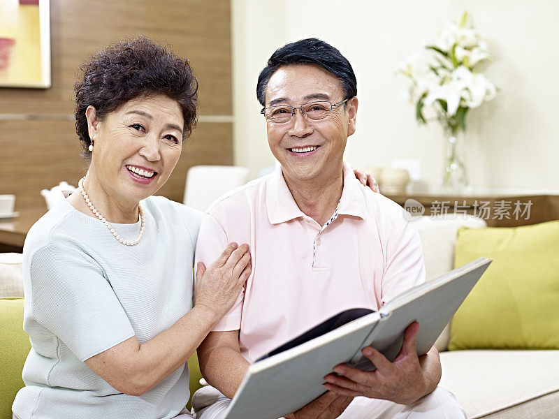 年老的亚洲夫妇在家里看书