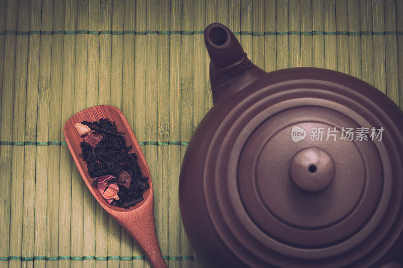 特写陶瓷茶壶在绿色竹子的背景。复古的过滤器。