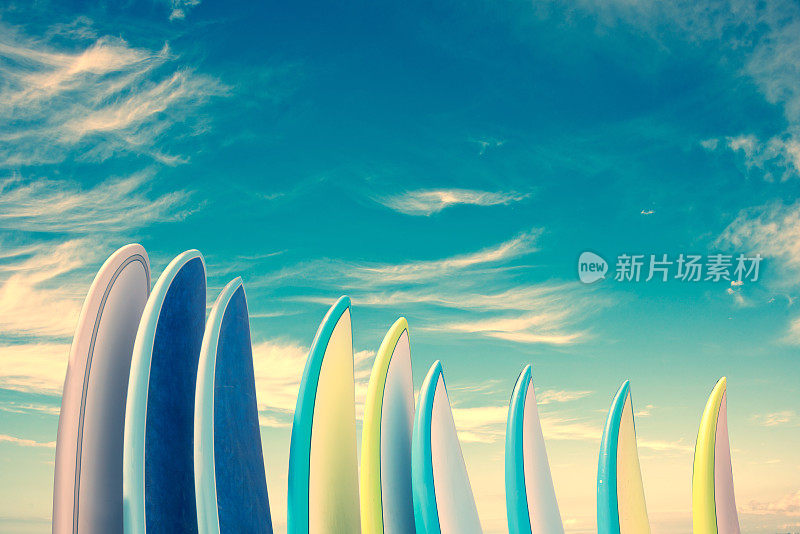 堆叠的彩色冲浪板在蓝天背景与拷贝空间，复古复古滤镜