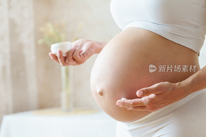 孕妇在腹部涂抹乳霜以防止皮肤上的妊娠纹