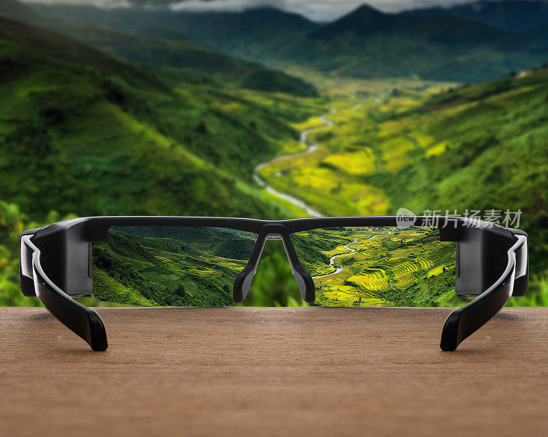 景观概念图像聚焦在眼镜镜头上方照片模糊的俯视图，可以看到水稻梯田背景