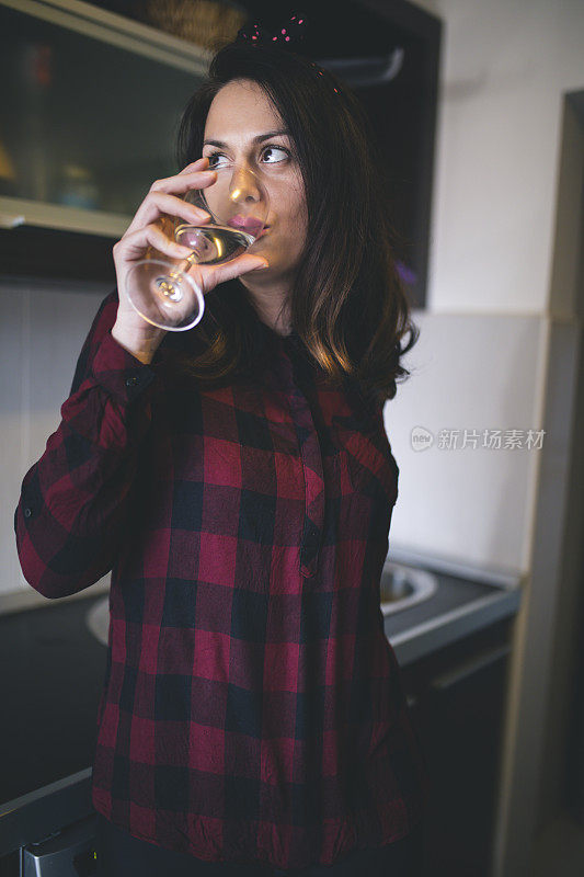 一个年轻漂亮的黑发女人喝香槟的画像
