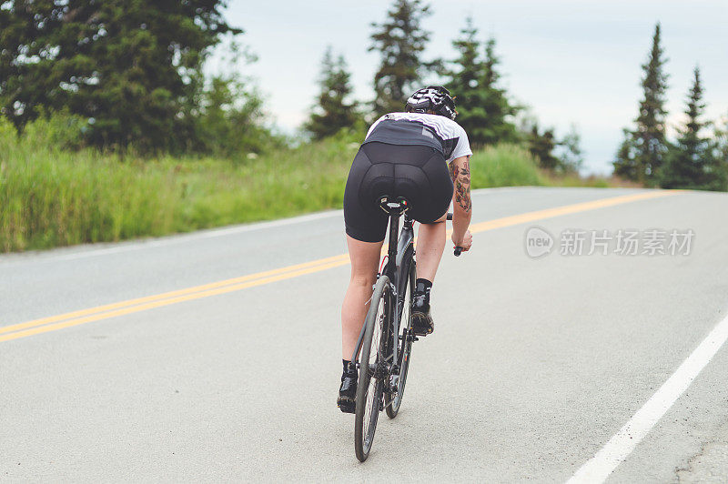 一名骑自行车的女性沿着乡村公路骑行