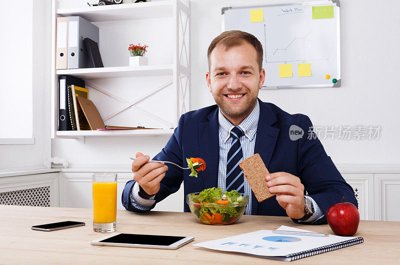 男人在现代的办公室里吃健康的商务午餐