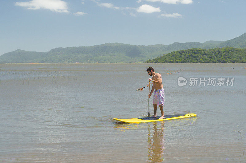年轻人在湖上练习立桨