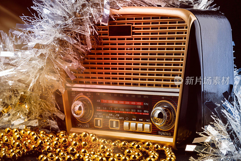 复古风格的收音机与圣诞装饰和光线在黑色背景