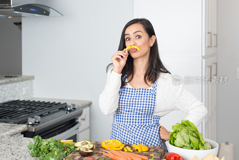 年轻的西班牙妇女举着一个甜椒