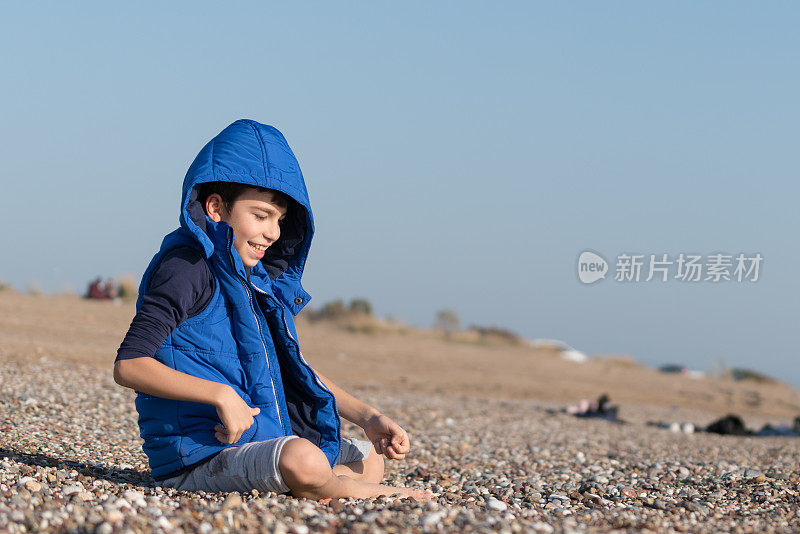 快乐的男孩在一个冬天的一天在沙滩上玩