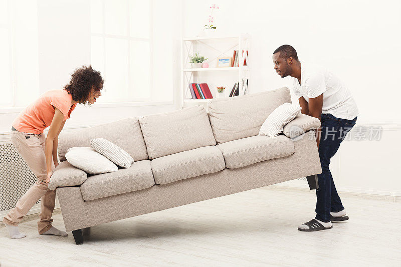 一对非洲裔美国夫妇在新家摆放沙发