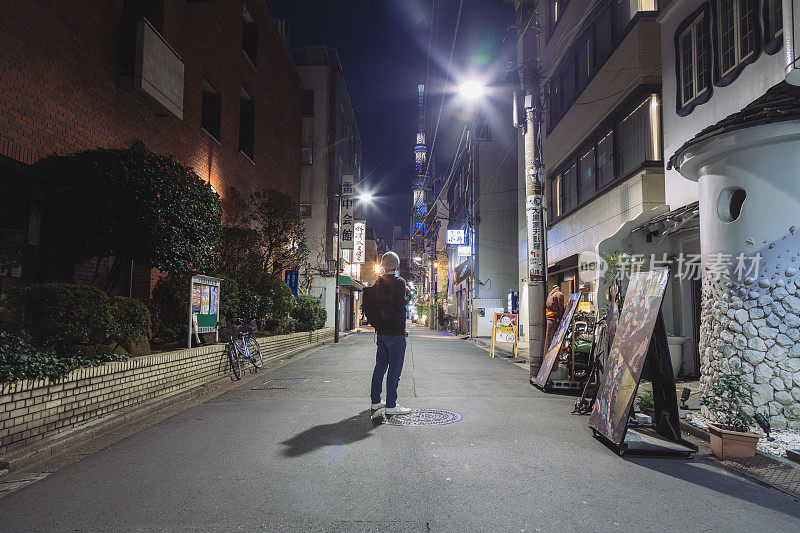 一名游客站在浅草的夜间街道上