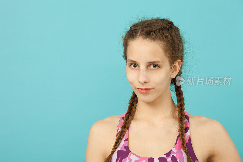 特写肖像的少女14岁在工作室的蓝色背景