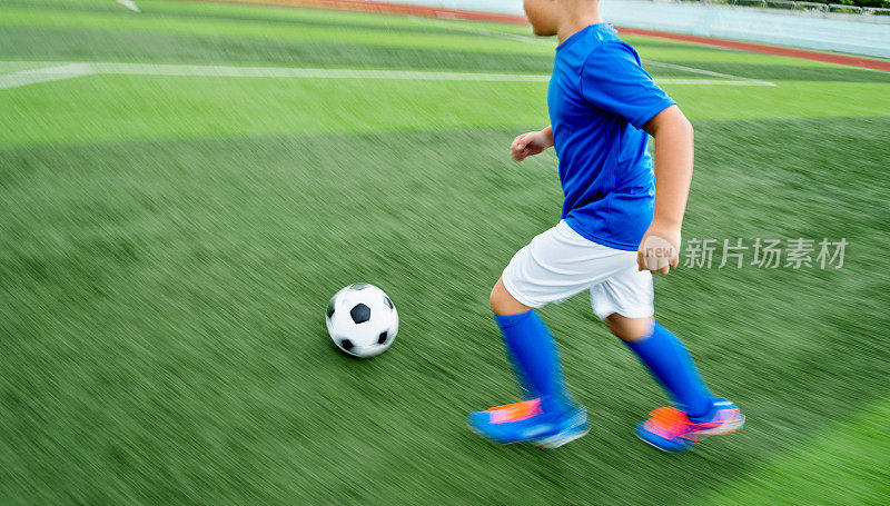 一个小男孩在追一个足球