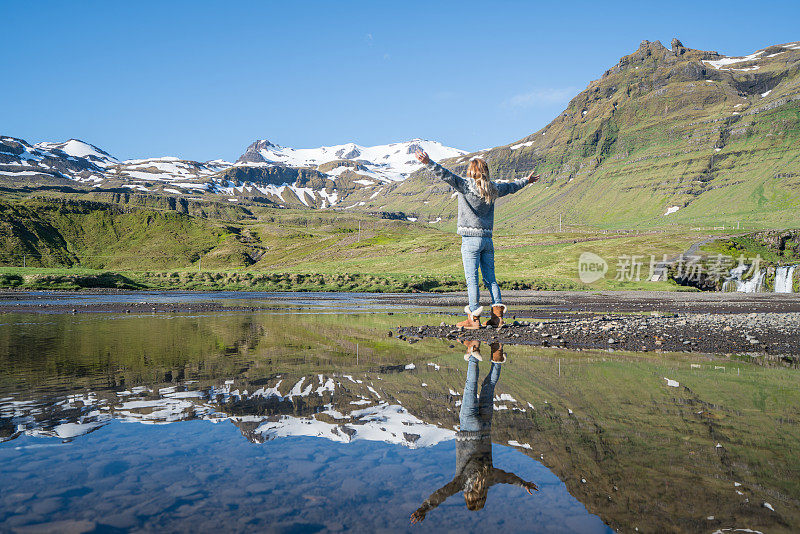 在冰岛，年轻女子张开双臂，渴望自由