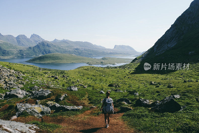 在挪威罗浮敦群岛的峡湾景色中徒步旅行的女人