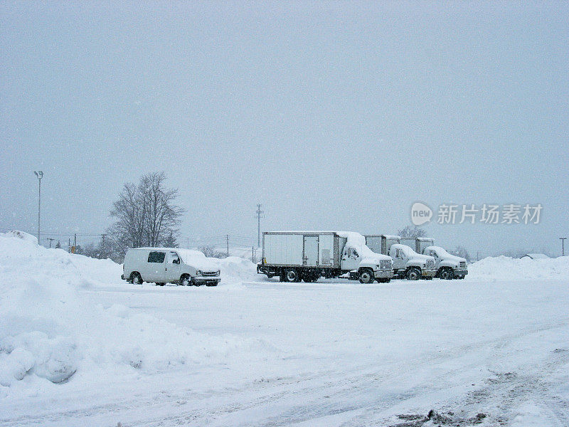 一排货车停在厚厚的冬雪中