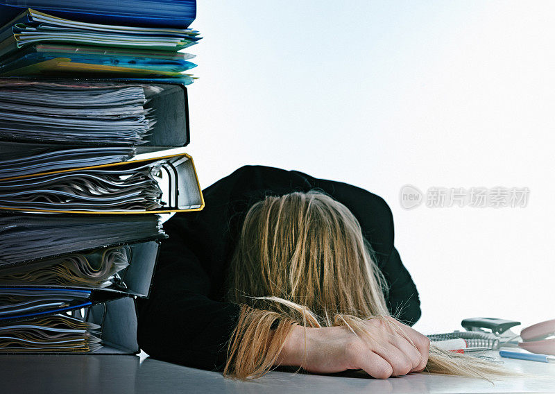 疲惫的办公室职员在一堆工作上睡着了