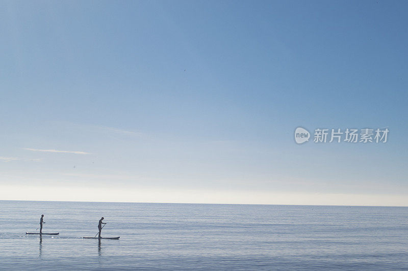 在平静的海面上划船的人