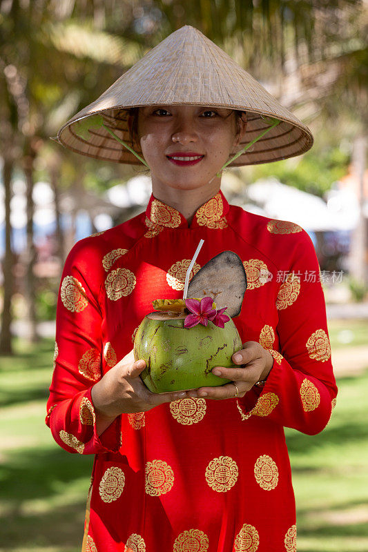 异国情调的传统越南女孩，同时提供新鲜的椰果和鲜花