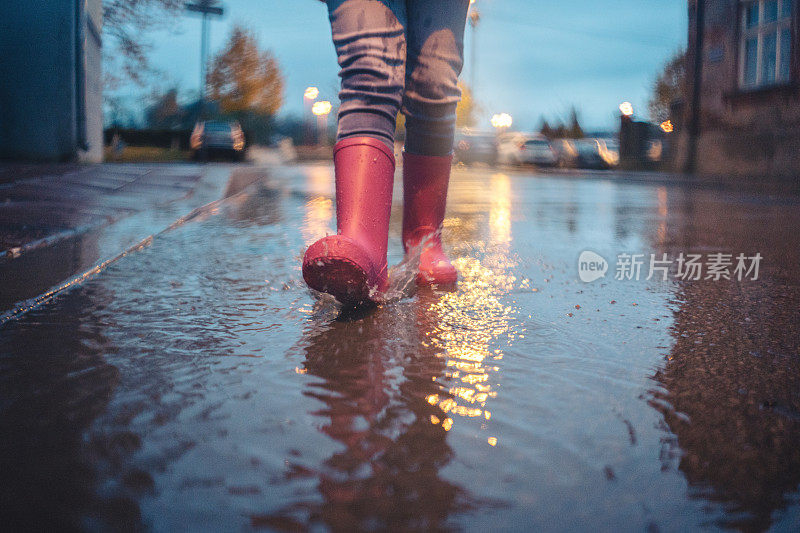 穿着雨靴走在水坑里