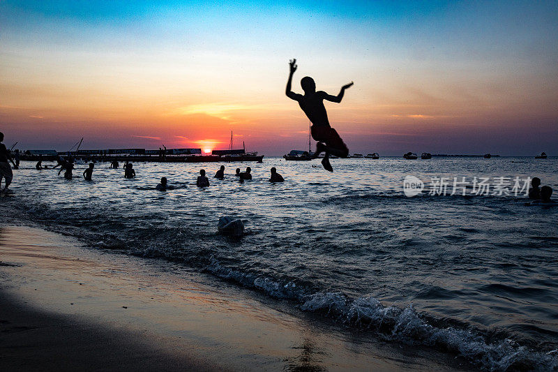 非洲男孩在桑给巴尔的夕阳下跳海