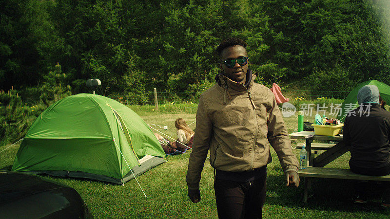 夏令营。一个非洲人站在帐篷前