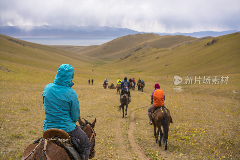 一大群骑马旅游的游客前往吉尔吉斯斯坦的松科尔湖