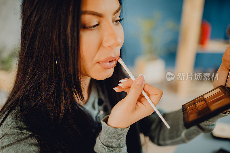 一个年轻女人化妆和涂唇线的特写