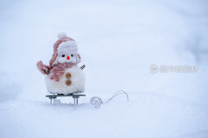 可爱的雪人在雪橇上。