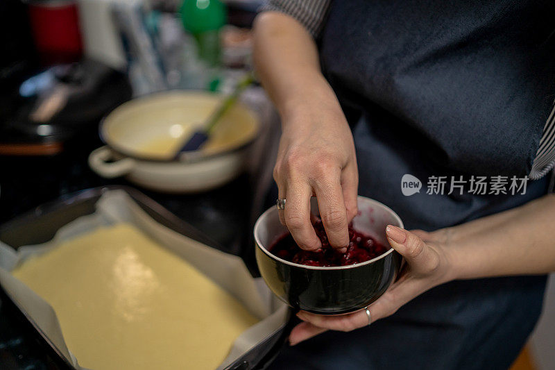 年轻女子在厨房做饭。樱桃饼