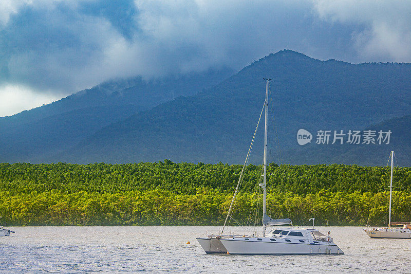 帆船和船只停泊在海湾与风暴的背景