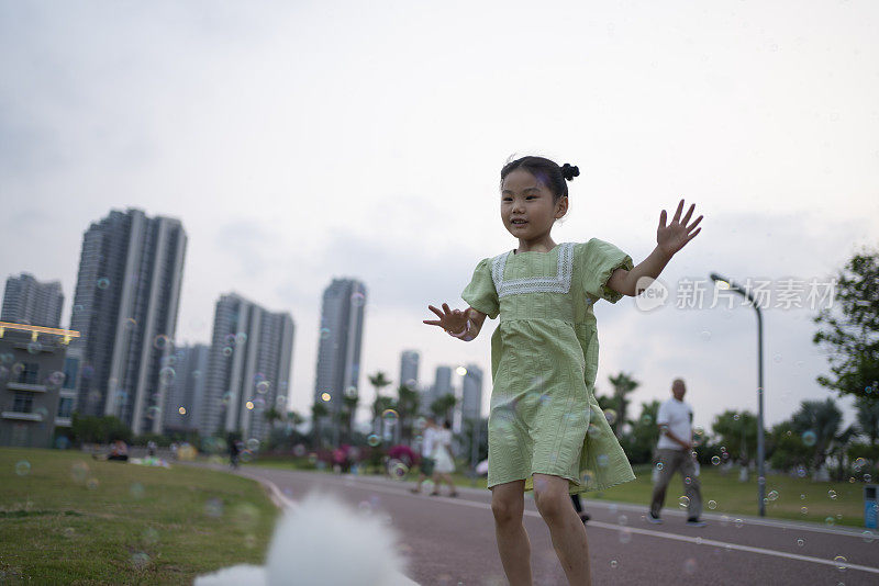 可爱的小女孩开心地玩着五颜六色的泡泡