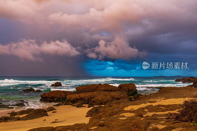 日落照亮的海洋上戏剧性的风暴单体系统的海岸海景