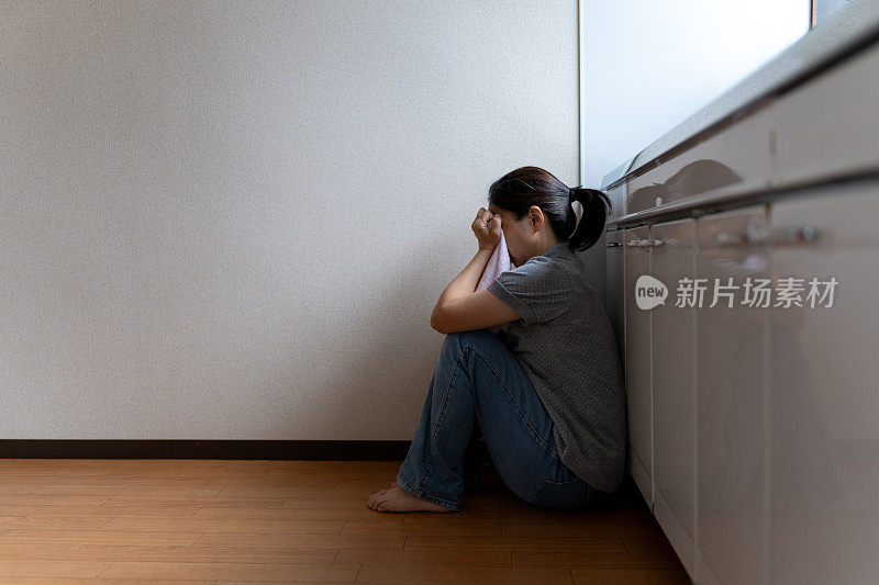 绝望的女人坐在厨房里