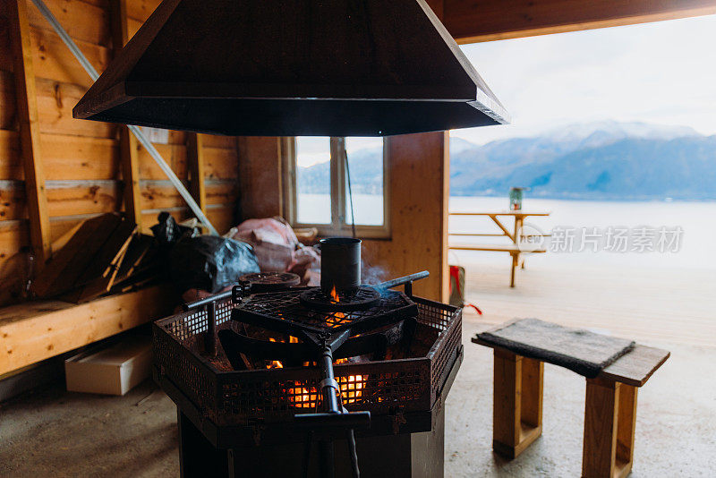 舒适的烛光和茶在明火上烹饪在挪威传统的山间小屋