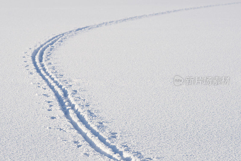 在冰冻的湖面上的雪地上越野滑雪道