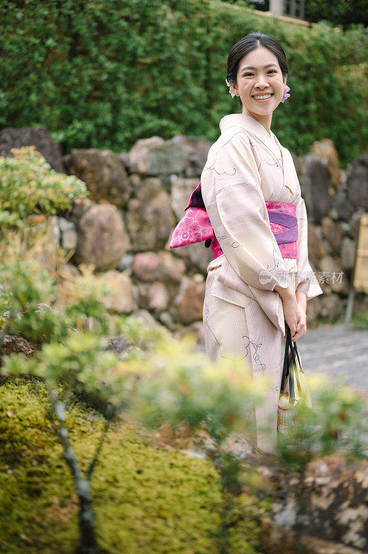 美丽的日本女士GenZ在户外公园拍摄穿着日本传统和服的旅行瞬间
