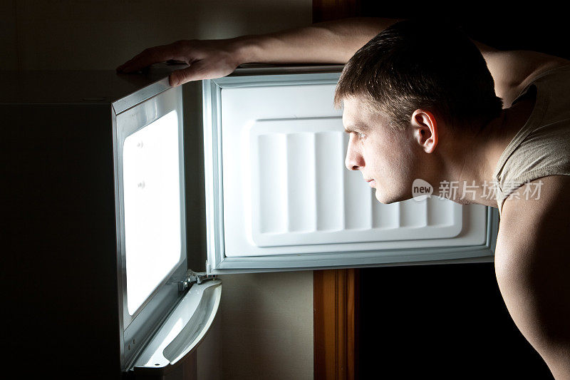 饥饿的人打开冰箱。