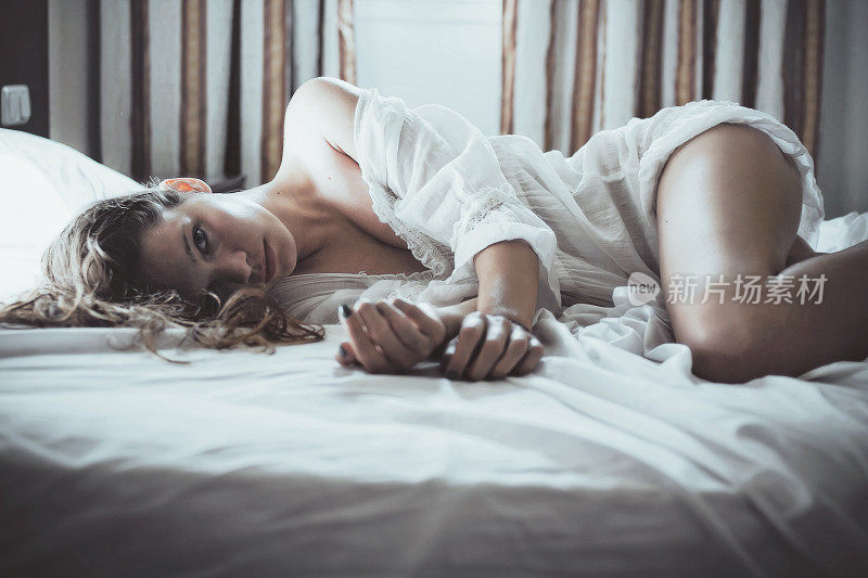 年轻性感的女人躺在床上