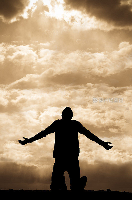 一个人跪着向天空祈祷的轮廓