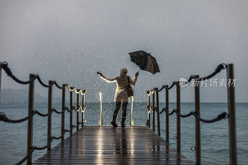 下雪天，一个女人撑着伞站在海边