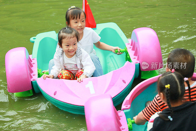 小亚洲女孩在脚踏船上玩