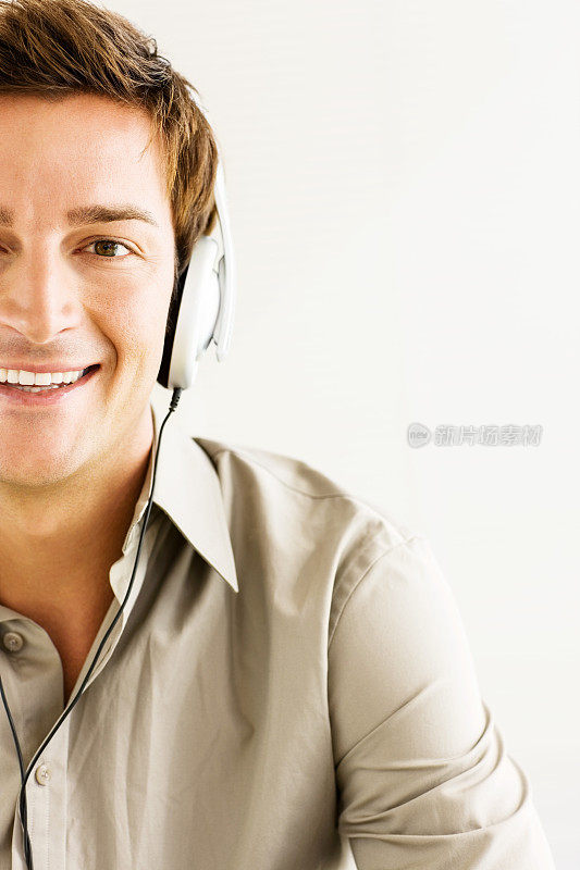 戴着耳机听音乐时微笑的男人