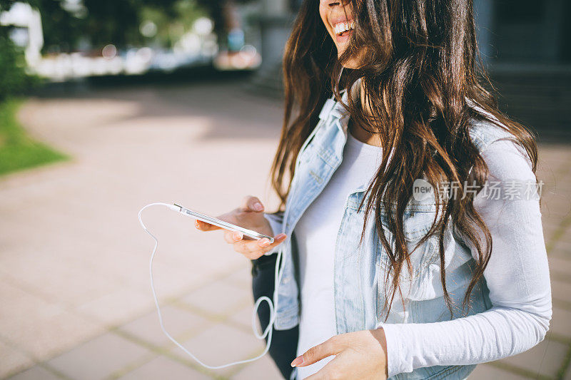 年轻的女学生正在听音乐